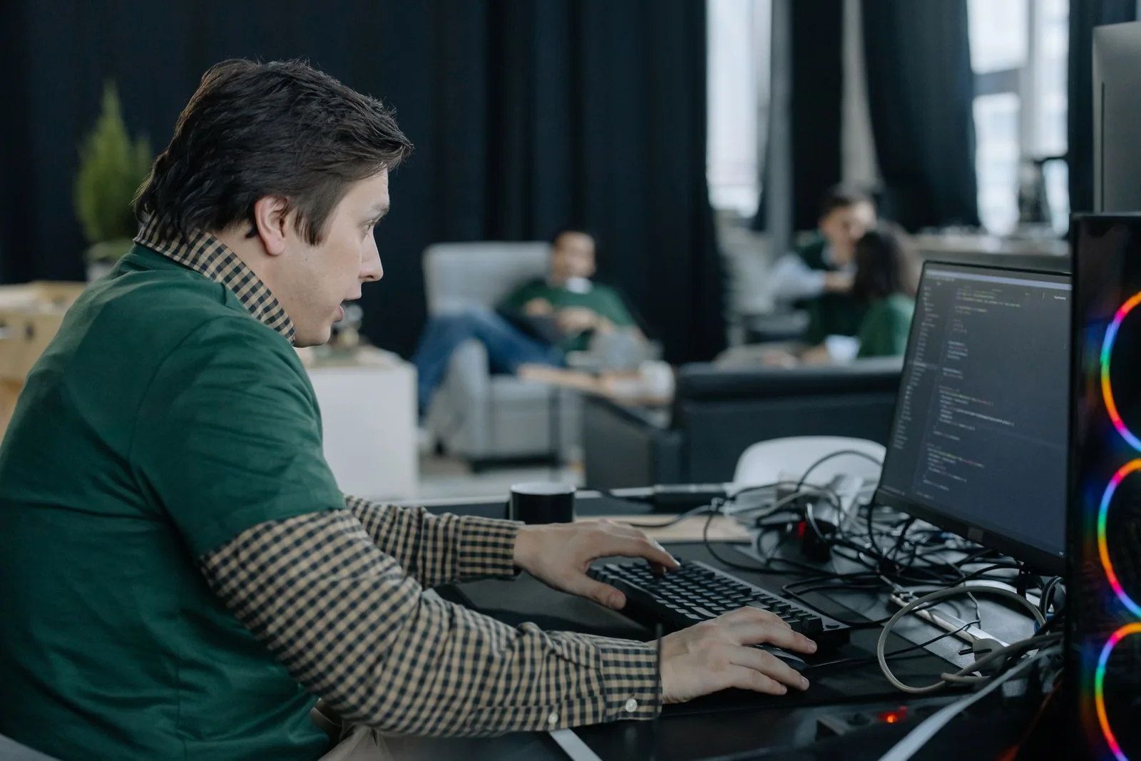 Developer concentrating on a desktop workstation in a shared studio