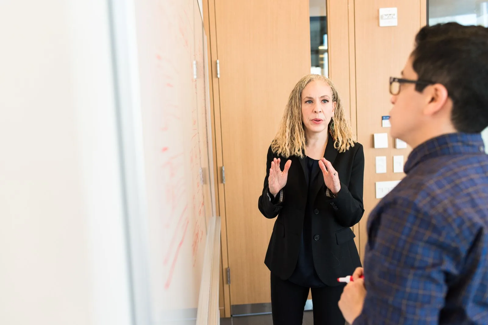 Colleagues discussing a plan at a whiteboard