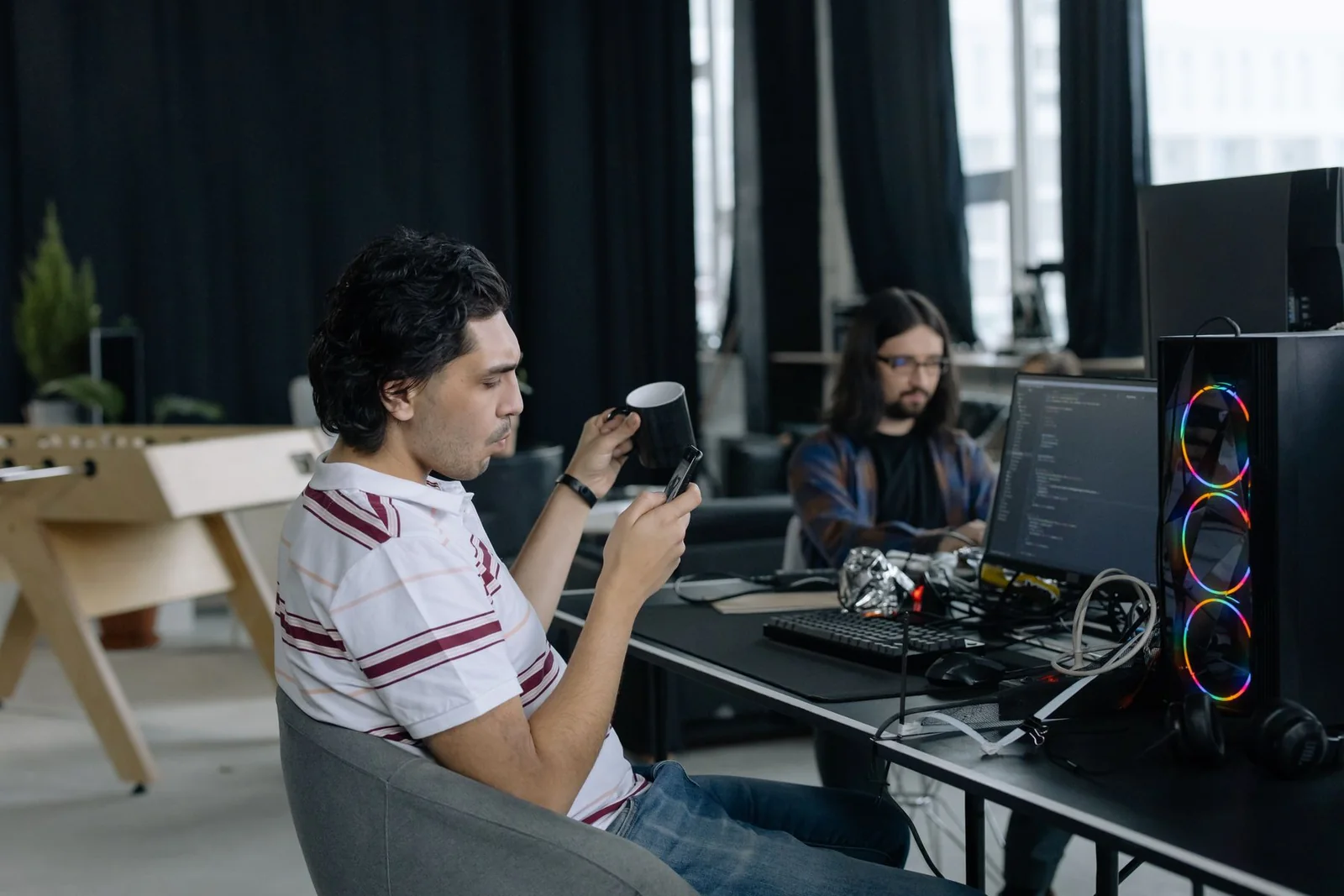 Two developers taking a break beside their workstations